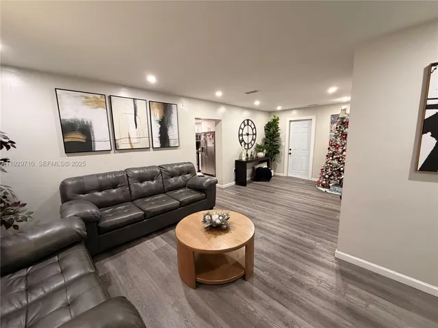 a living room with furniture and a wooden floor