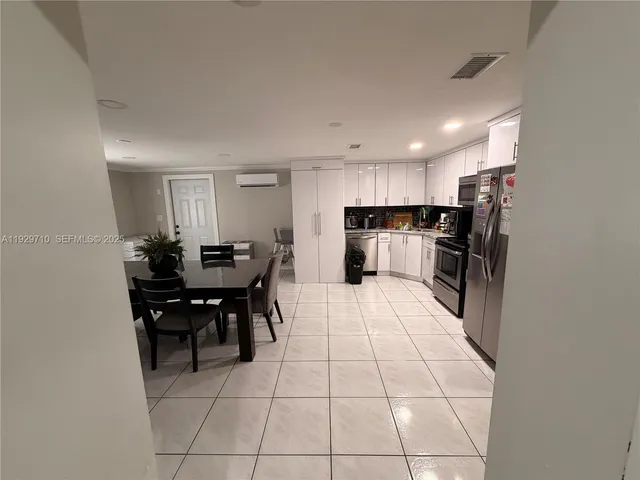 a kitchen with a sink a refrigerator and chairs