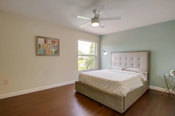 a bedroom with a bed and a ceiling fan
