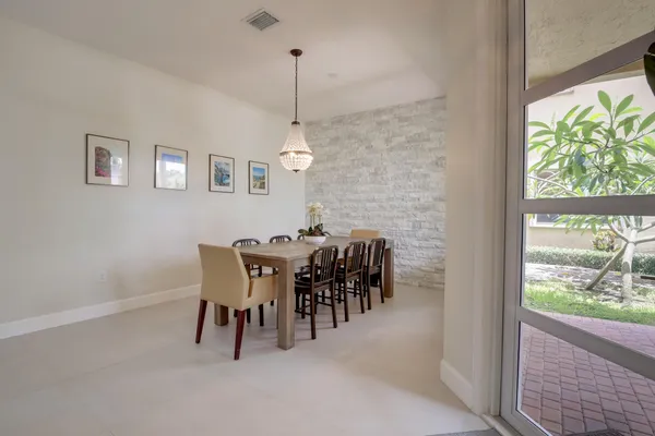a view of a dining room and livingroom with furniture wooden floor a chandelier