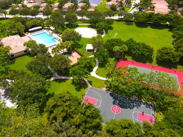 an aerial view of a house with a swimming pool a yard and a fountain