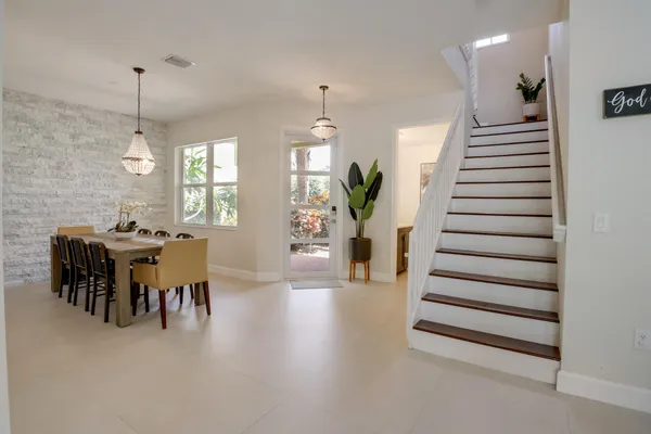 a dining room with wooden floor a chandelier a wooden table and chairs