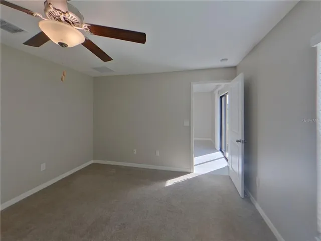 a view of a room with a ceiling fan and window