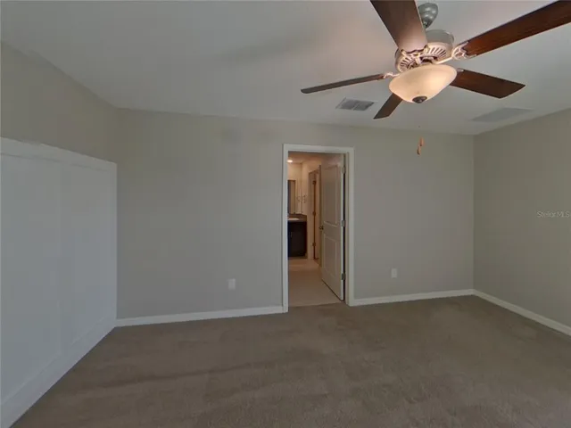 an empty room with a window and a fan