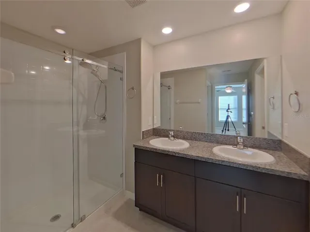 a bathroom with double vanity sinks double vanity and a shower