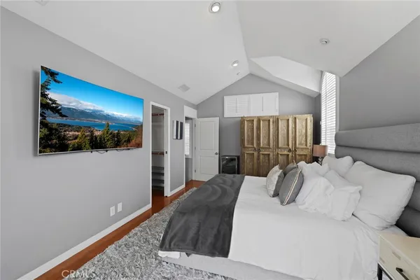 a bedroom with a large bed and a painting on the wall