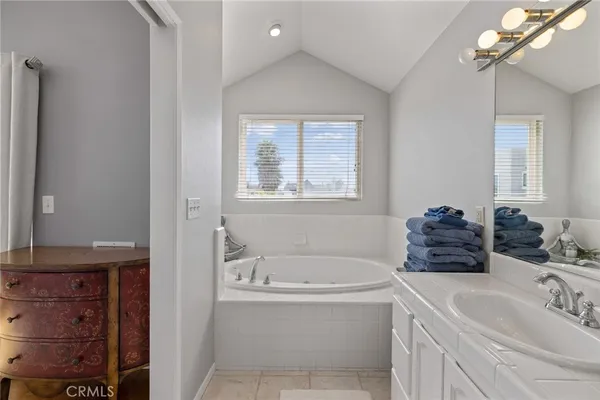 a bathroom with a tub sink and mirror