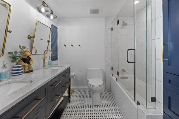 a bathroom with a granite countertop sink toilet a shower and a mirror