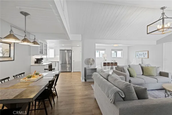 a living room with furniture kitchen view and a chandelier