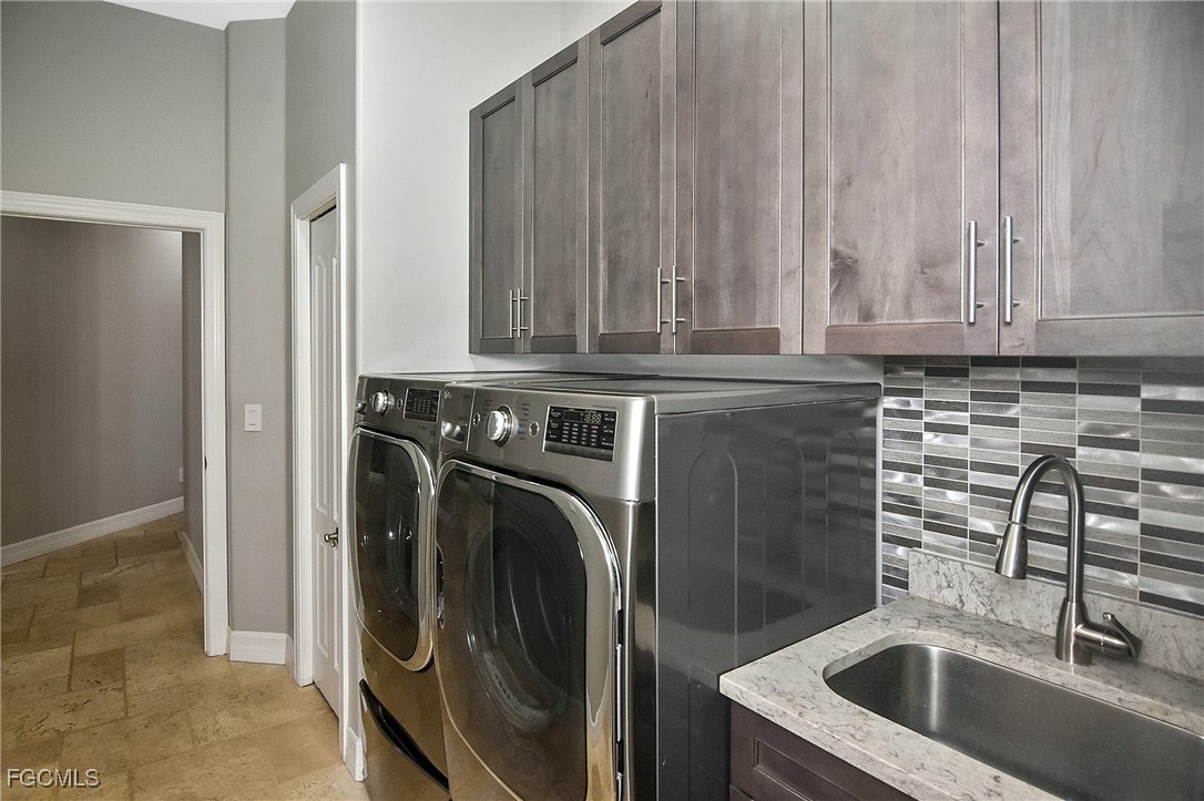 11066 Seminole Palm Way Fort Myers, FL 33966 - Photo 28 of 46 a kitchen with a sink a washer and dryer