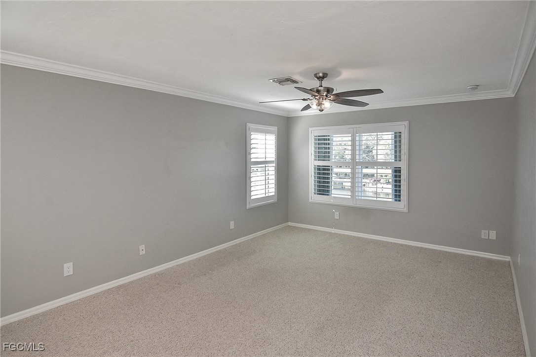 11066 Seminole Palm Way Fort Myers, FL 33966 - Photo 34 of 46 an empty room with windows and ceiling fan