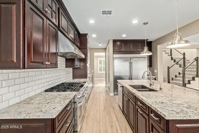 a kitchen with stainless steel appliances granite countertop a sink stove and refrigerator