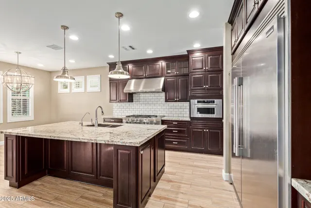 a kitchen with a counter top space a sink appliances and cabinets