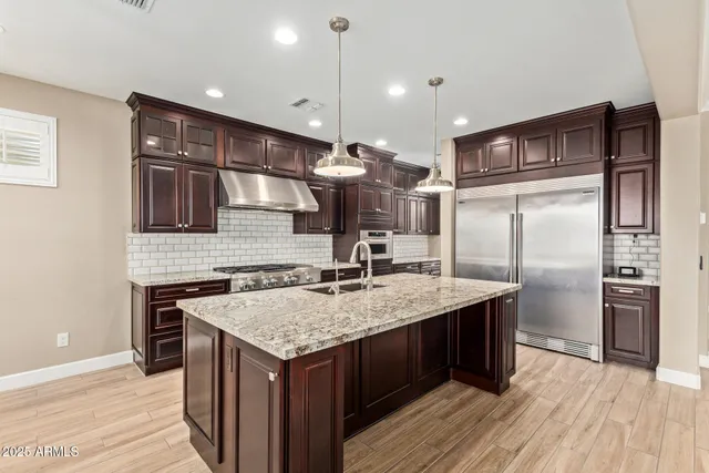 a kitchen with kitchen island a counter top space cabinets and stainless steel appliances