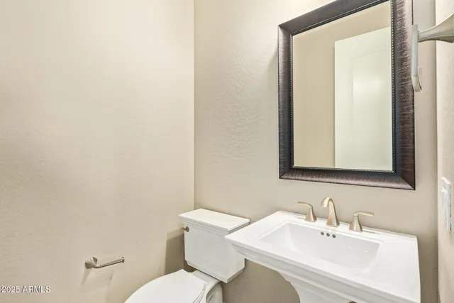 a bathroom with a sink vanity mirror and toilet