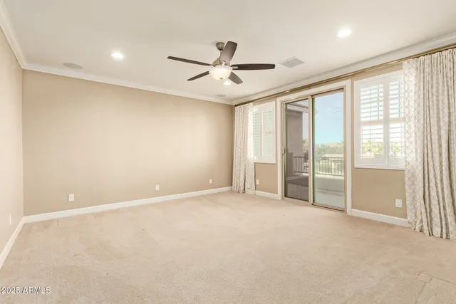 an empty room with windows and ceiling fan