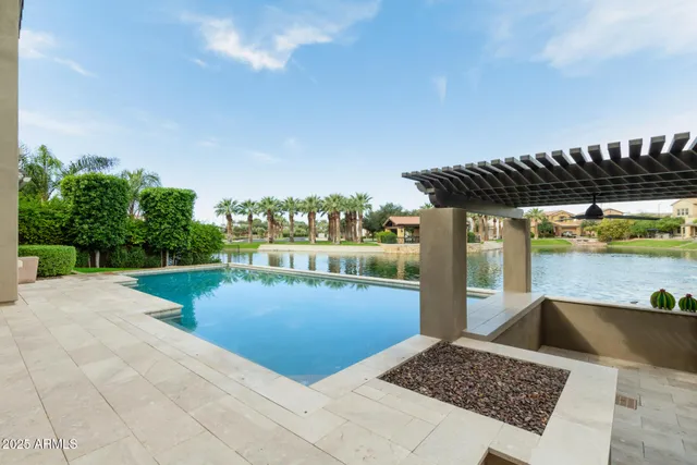 a view of a swimming pool with a patio and a yard