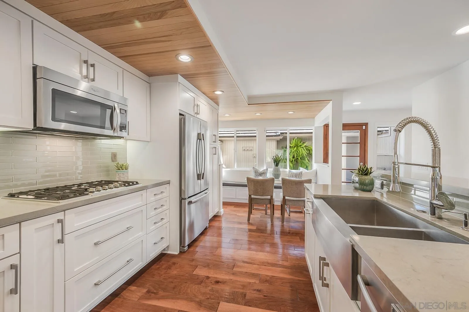 3040 Via De Caballo Encinitas, CA 92024 - Photo 7 of 39 a kitchen with stainless steel appliances granite countertop a stove a sink a refrigerator and white cabinets with wooden floors
