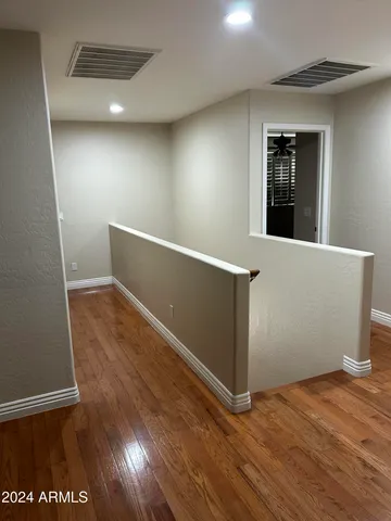 a view of a hallway with wooden floor and staircase
