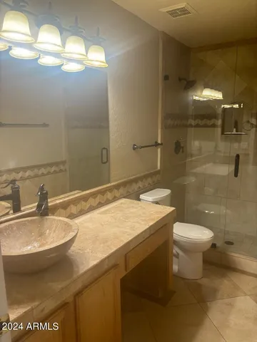 a view of an empty room with a chandelier fan