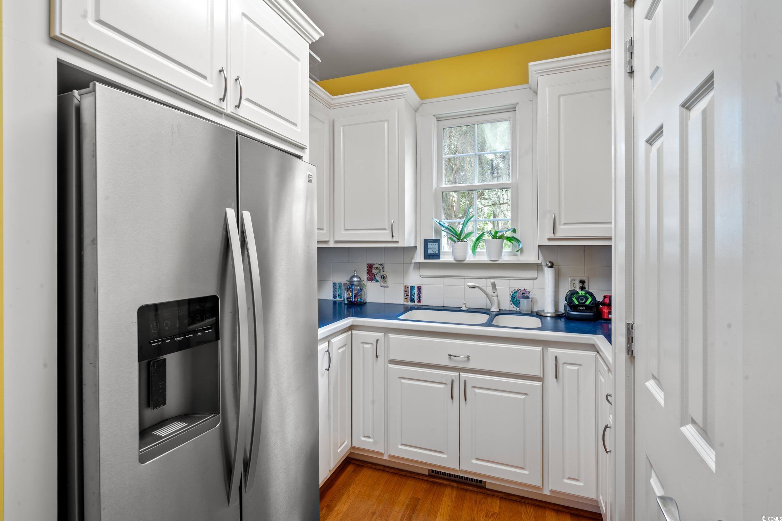 700 Lakeside Drive Conway, SC 29526 - Photo 11 of 40 Kitchen with stainless steel refrigerator with ice dispenser, white cabinetry, decorative backsplash, and light wood-style floors
