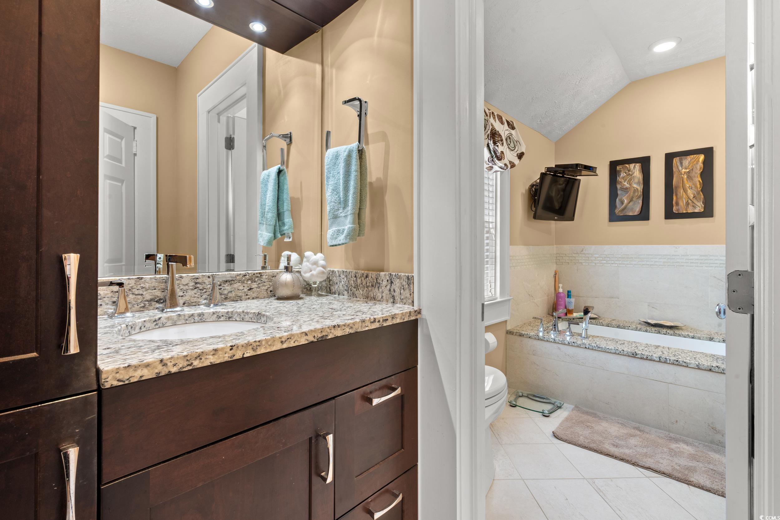700 Lakeside Drive Conway, SC 29526 - Photo 20 of 40 Bathroom featuring vanity, a bath, light tile patterned flooring, vaulted ceiling, and recessed lighting
