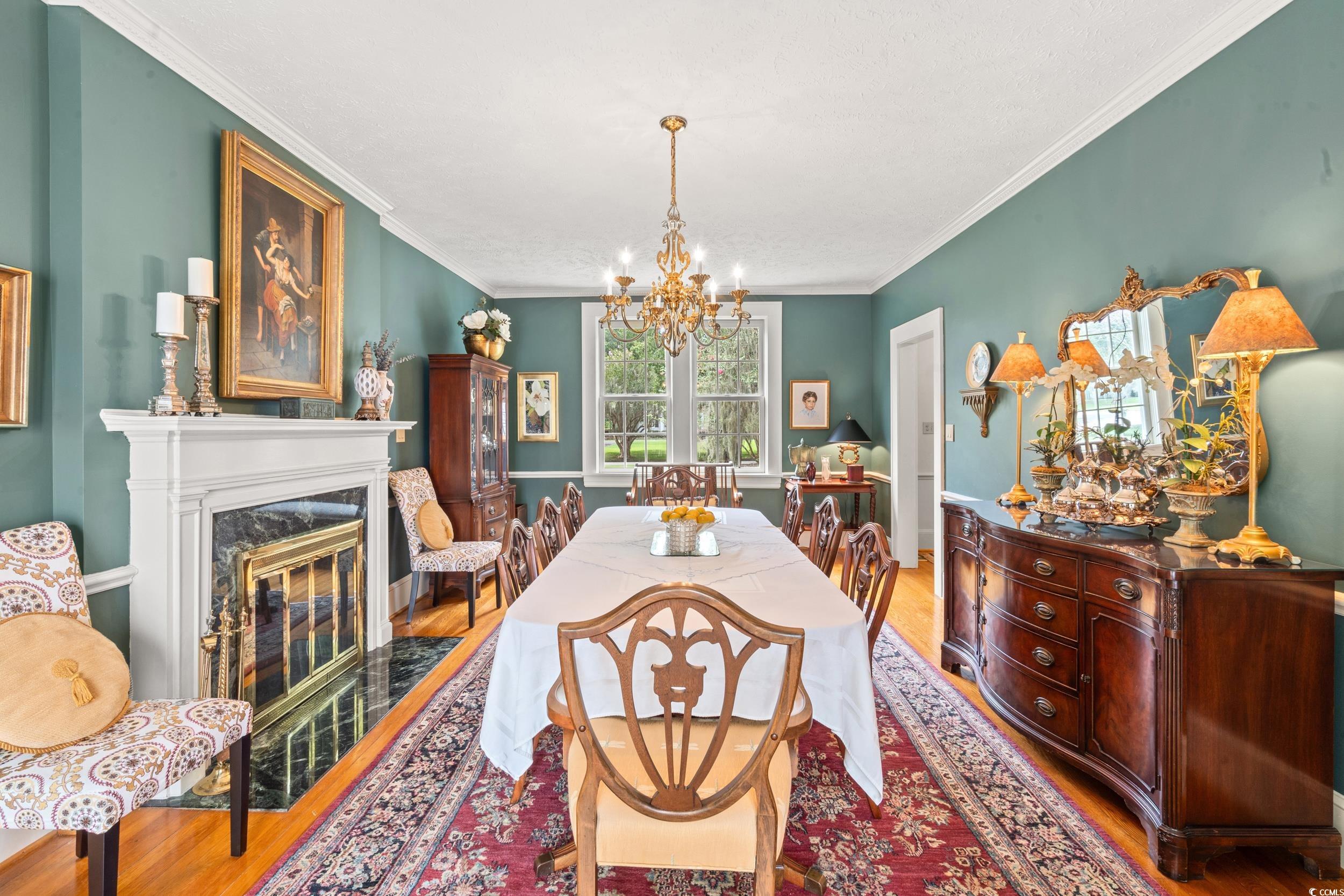 700 Lakeside Drive Conway, SC 29526 - Photo 6 of 40 Dining room featuring wood finished floors, a chandelier, a high end fireplace, and crown molding