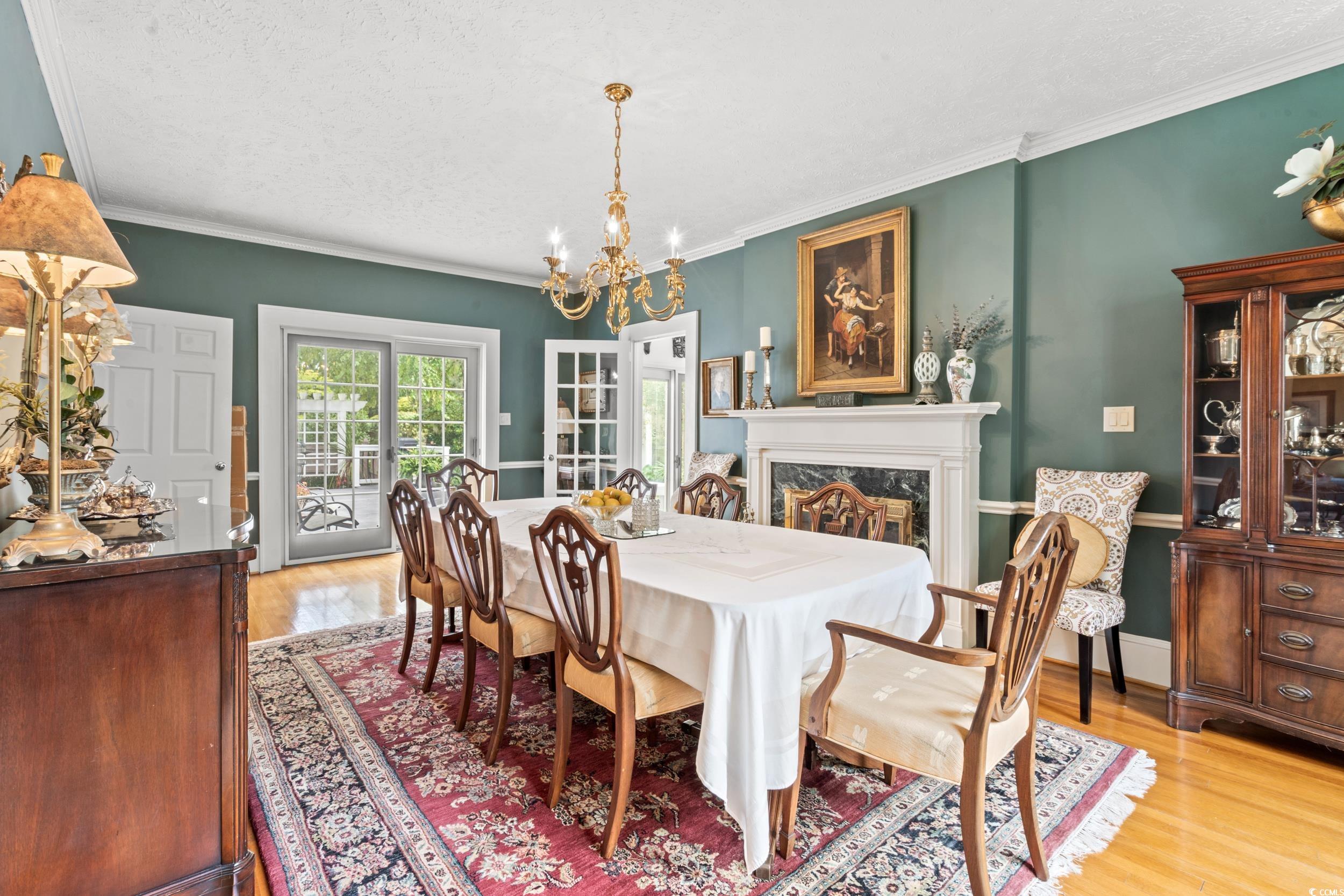 700 Lakeside Drive Conway, SC 29526 - Photo 7 of 40 Dining space with a chandelier, light wood-style flooring, crown molding, a textured ceiling, and a high end fireplace