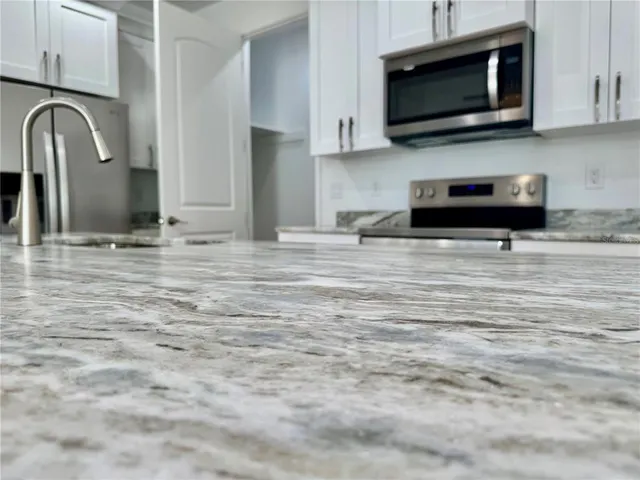 a kitchen with stainless steel appliances a stove a microwave and sink