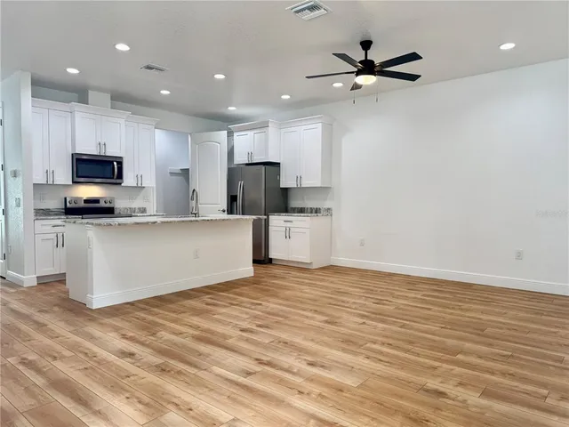 a kitchen with stainless steel appliances a refrigerator sink and microwave
