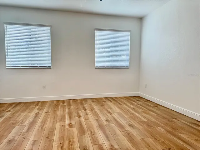 an empty room with wooden floor and a window