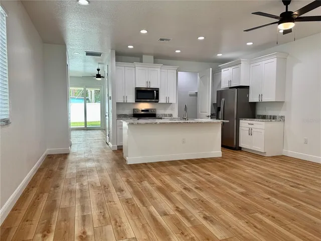 a kitchen with stainless steel appliances a refrigerator sink and microwave