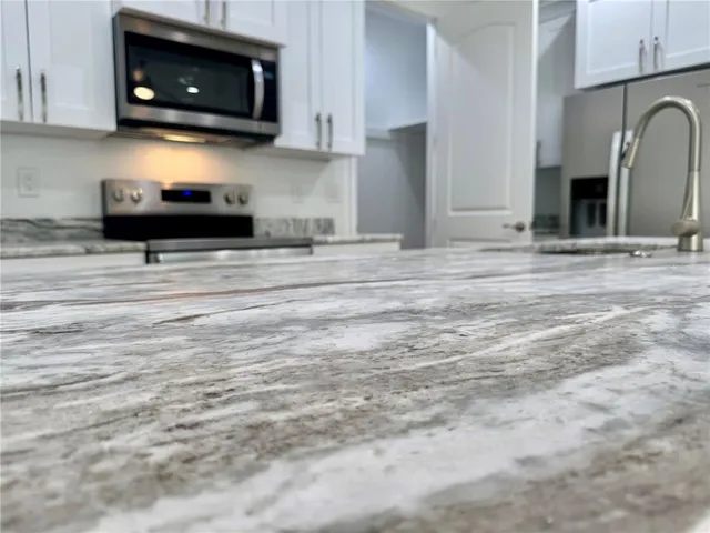 a kitchen with stainless steel appliances a stove a microwave and cabinets