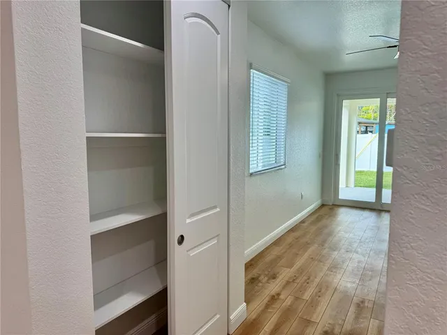 a view of an empty room with closet and a window