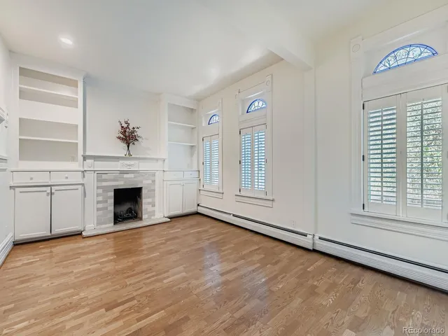 a view of an empty room with a window and fireplace