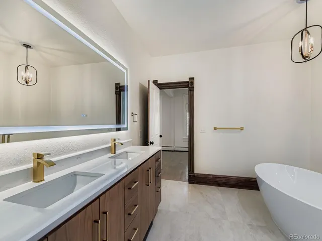 a bathroom with a granite countertop sink a toilet and mirror