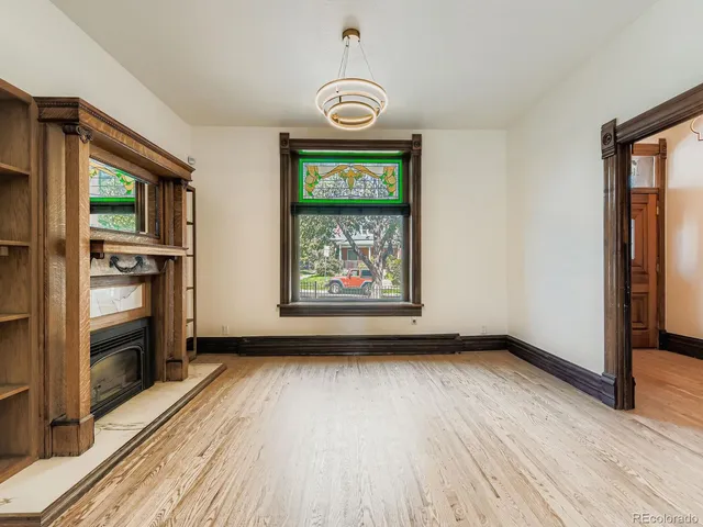 a view of an empty room window and wooden floor