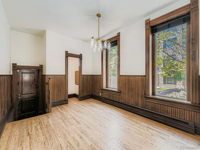 a view of a kitchen with wooden floor and a refrigerator