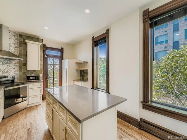 a kitchen with stainless steel appliances granite countertop a sink and a refrigerator