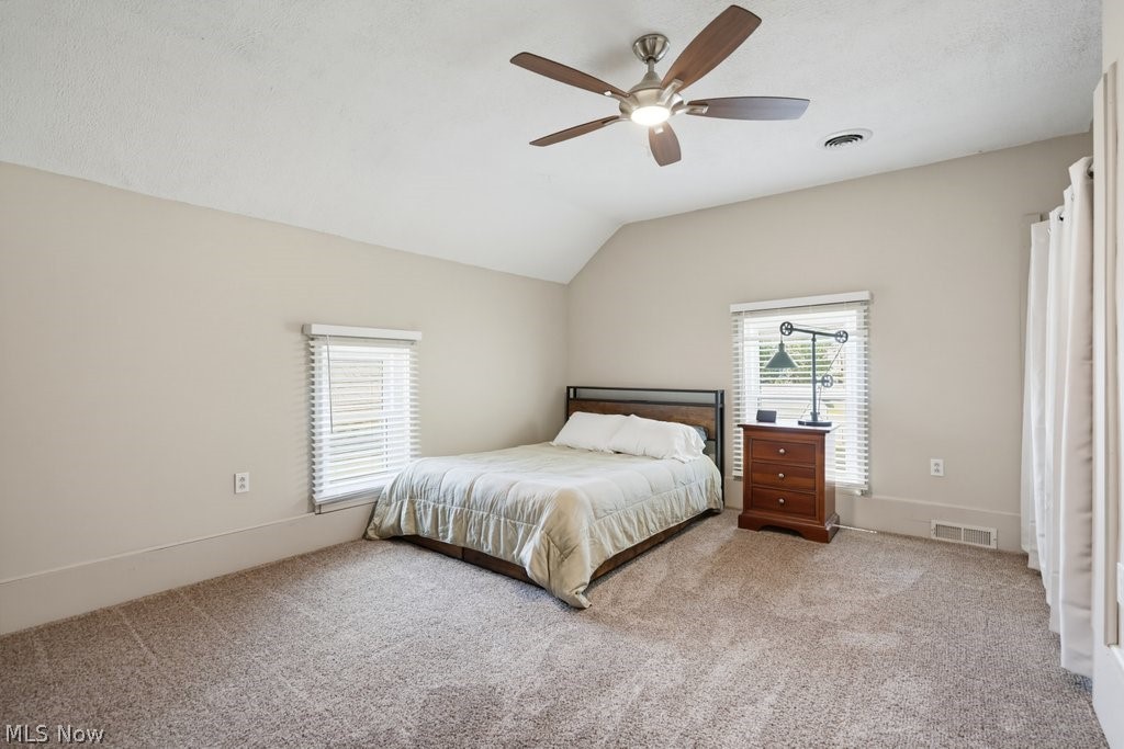 23055 Snell Road Columbia Station, OH 44028 - Photo 34 of 50 Carpeted room featuring an angled ceiling, two windows with blinds, and a ceiling fan with integrated lighting
