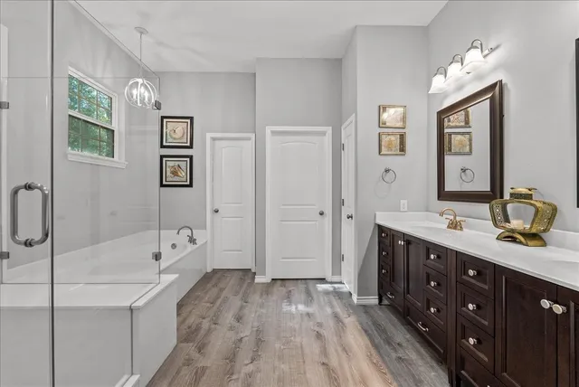 a spacious bathroom with a double vanity sink a mirror and a bathtub
