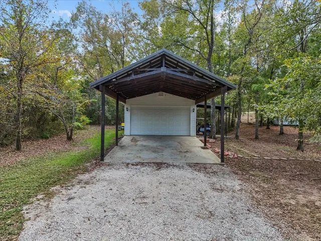 a view of a house with a yard and large trees