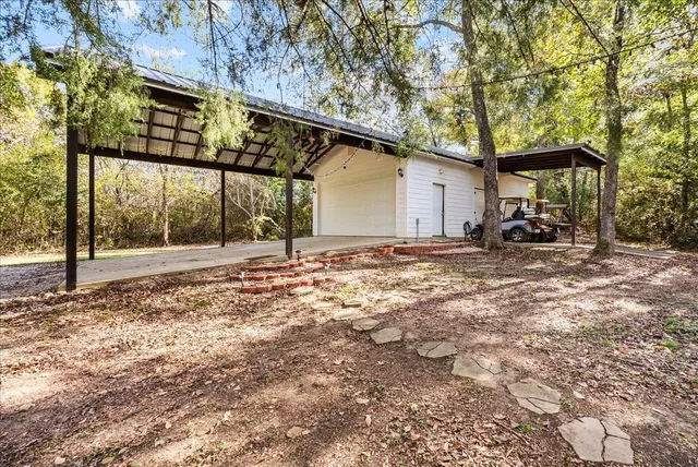 a backyard of a house with barbeque oven and table and chairs