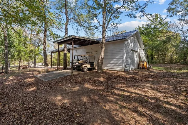 a backyard of a house with barbeque oven table and chairs