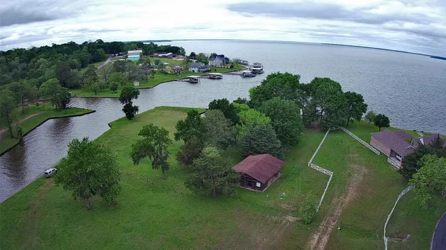 an aerial view of a house with a garden and lake view