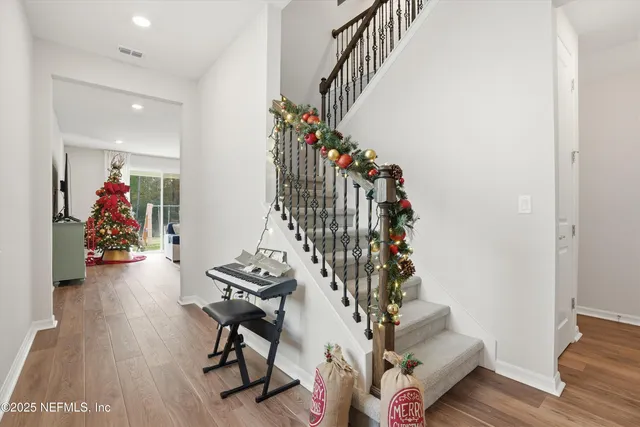 a view of a hallway with wooden floor and stairs