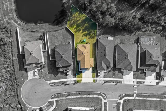 an aerial view of a house with swimming pool and outdoor seating