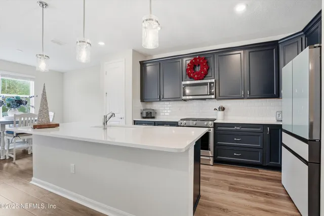 a kitchen with stainless steel appliances a sink stove and refrigerator