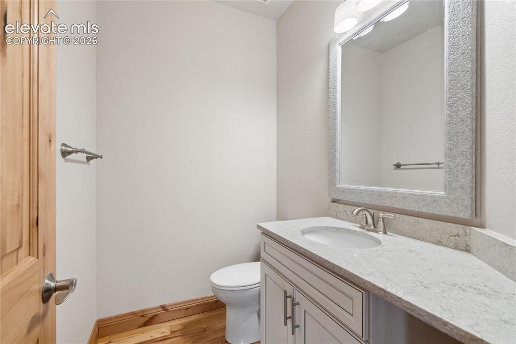 10840 Vollmer Road Colorado Springs, CO 80908 - Photo 31 of 49 a bathroom with a granite countertop sink toilet and a mirror