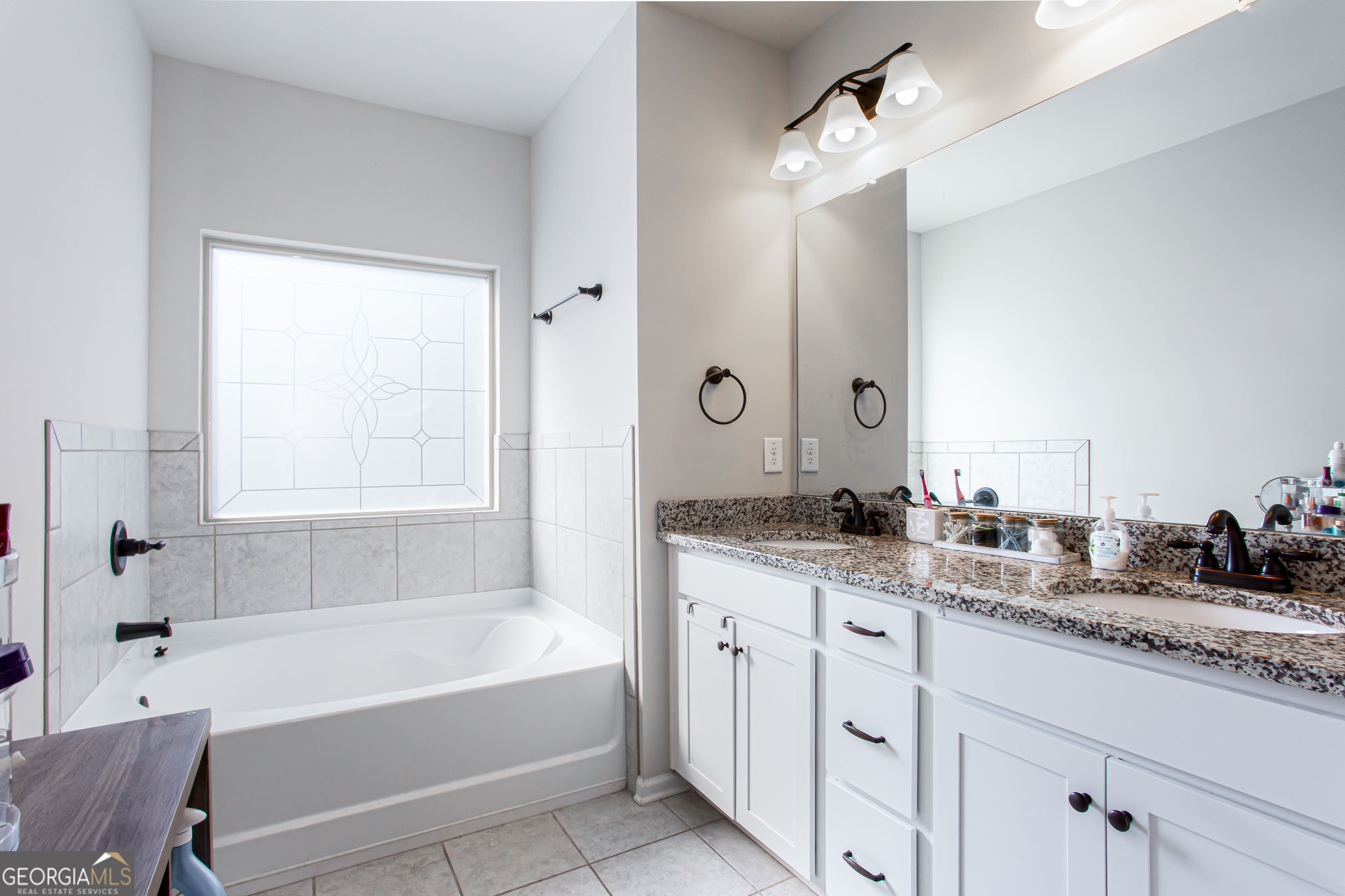 95 Bromes Street Lawrenceville, GA 30046 - Photo 20 of 37 a bathroom with a granite countertop sink mirror bathtub and next to a window
